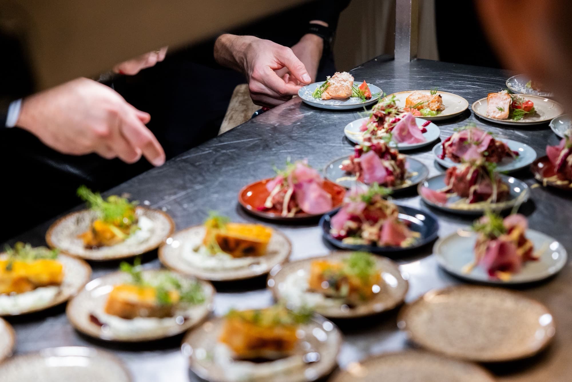 Chefs plating dishes at the pass